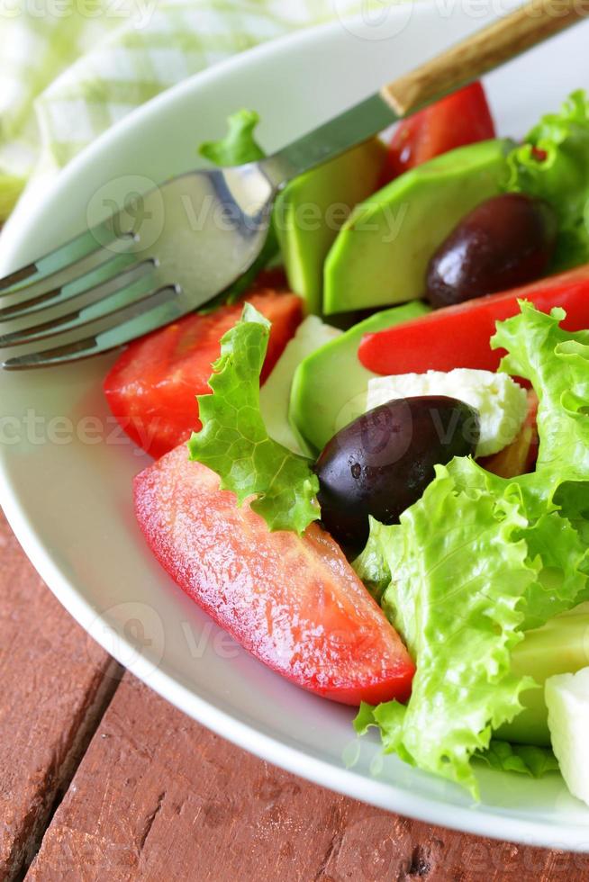 mediterrane salade met zwarte olijven, sla, kaas en tomaten foto