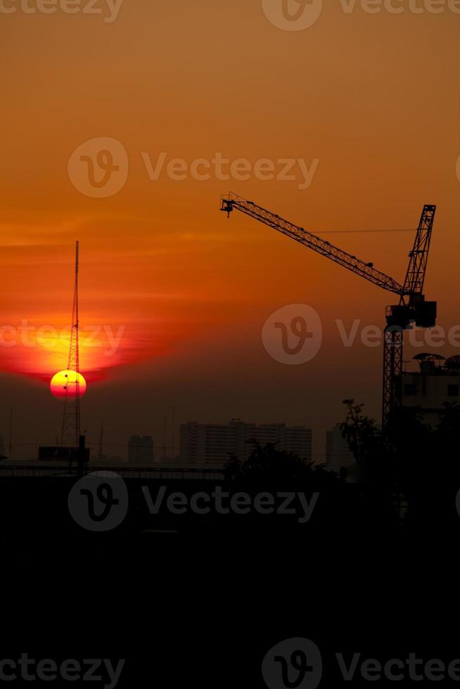 kraan in bouwwerf bij zonsondergang foto