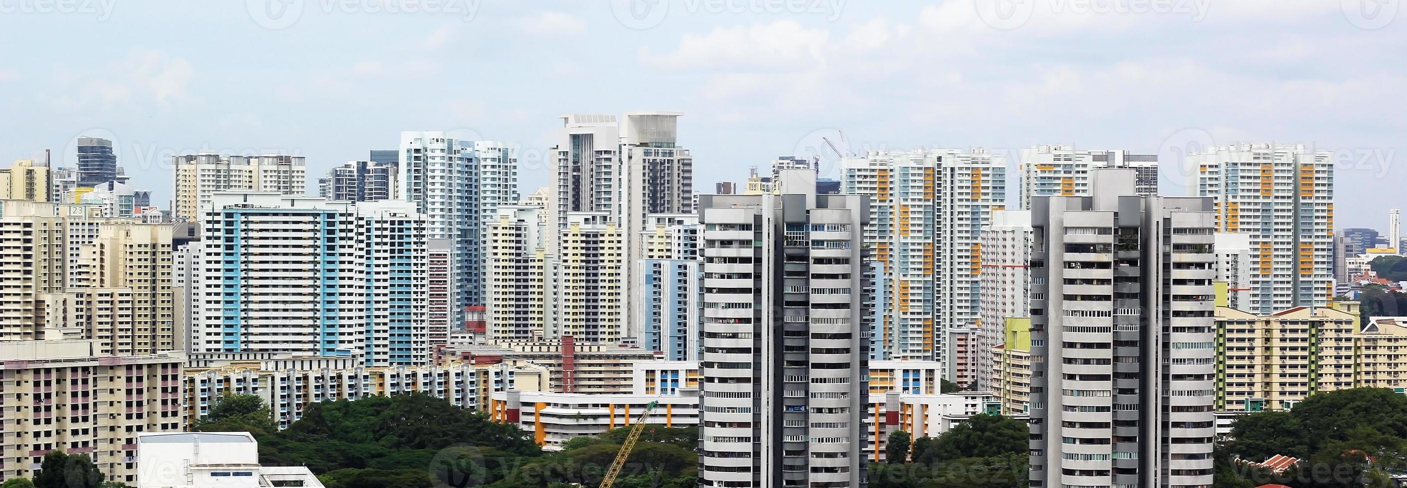 stadsgezicht van veel moderne hoge wolkenkrabber condominiums, appartementen, met huizen op de voorgrond. gebouwen, singapore, stadsgebied. foto