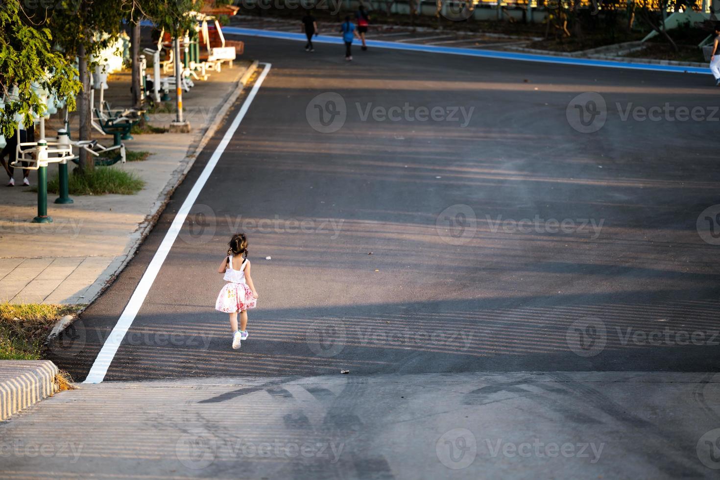 achteraanzicht van Aziatische jongen meisje joggen in het park op zomer- of lenteavond. kind sporten voor een goede gezondheid. kinderen 5 jaar. foto