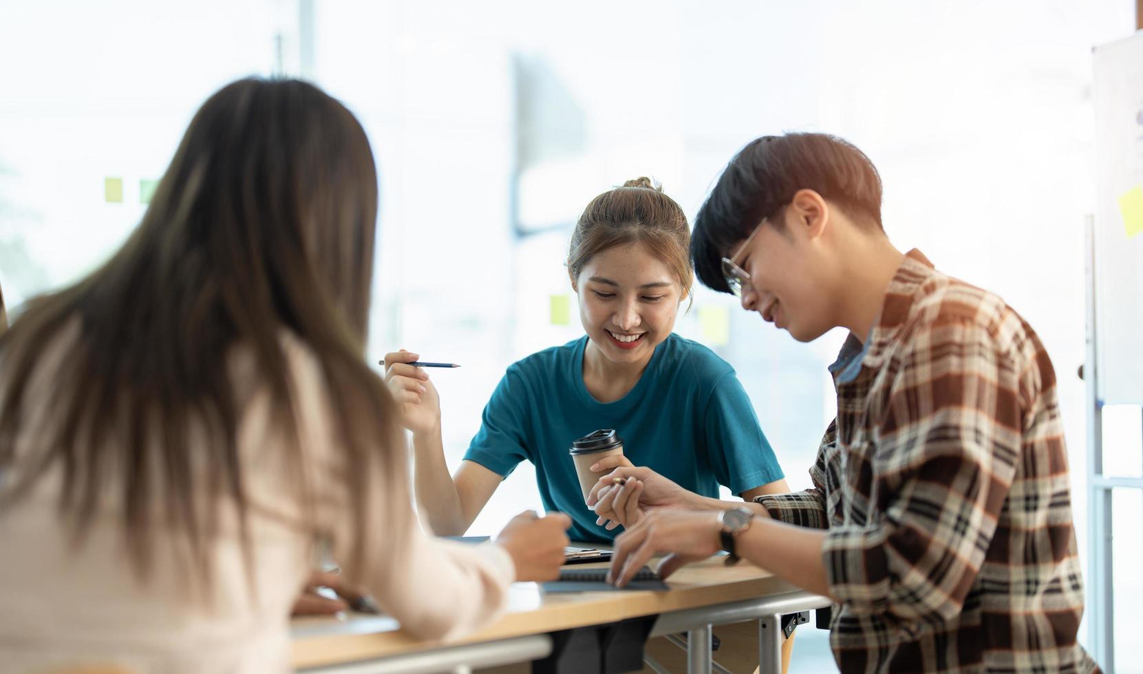 jonge aziatische vrouw leidt zakelijk creatief team in ontwerpproject voor mobiele applicatiesoftware. brainstormvergadering, samenwerken, internettechnologie, girlpower, teamwerkconcept voor kantoormedewerkers. foto