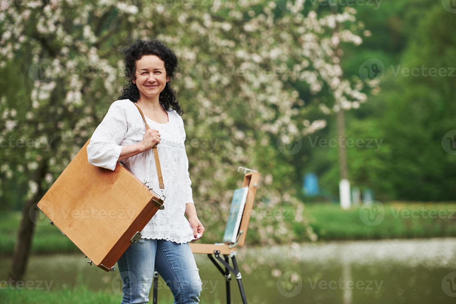 klaar voor een werk. volwassen schilder met koffer met instrumenten maak een wandeling in het prachtige lentepark foto