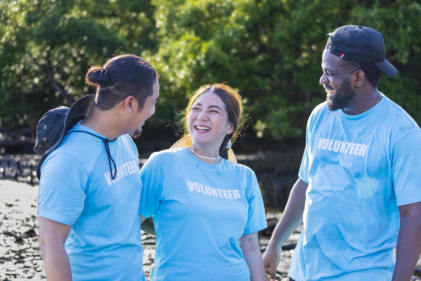 team van jonge en diversiteitsvrijwilligersgroep geniet van liefdadig sociaal werk buiten in het mangroveplantproject foto