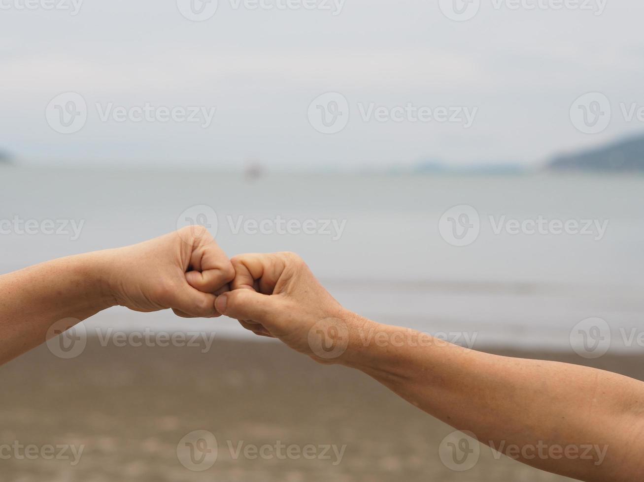 twee vrouwen alternatieve handdrukken vuist gebalde hand groet in de situatie van een epidemie covid 19, coronavirus nieuwe normale sociale afstand foto