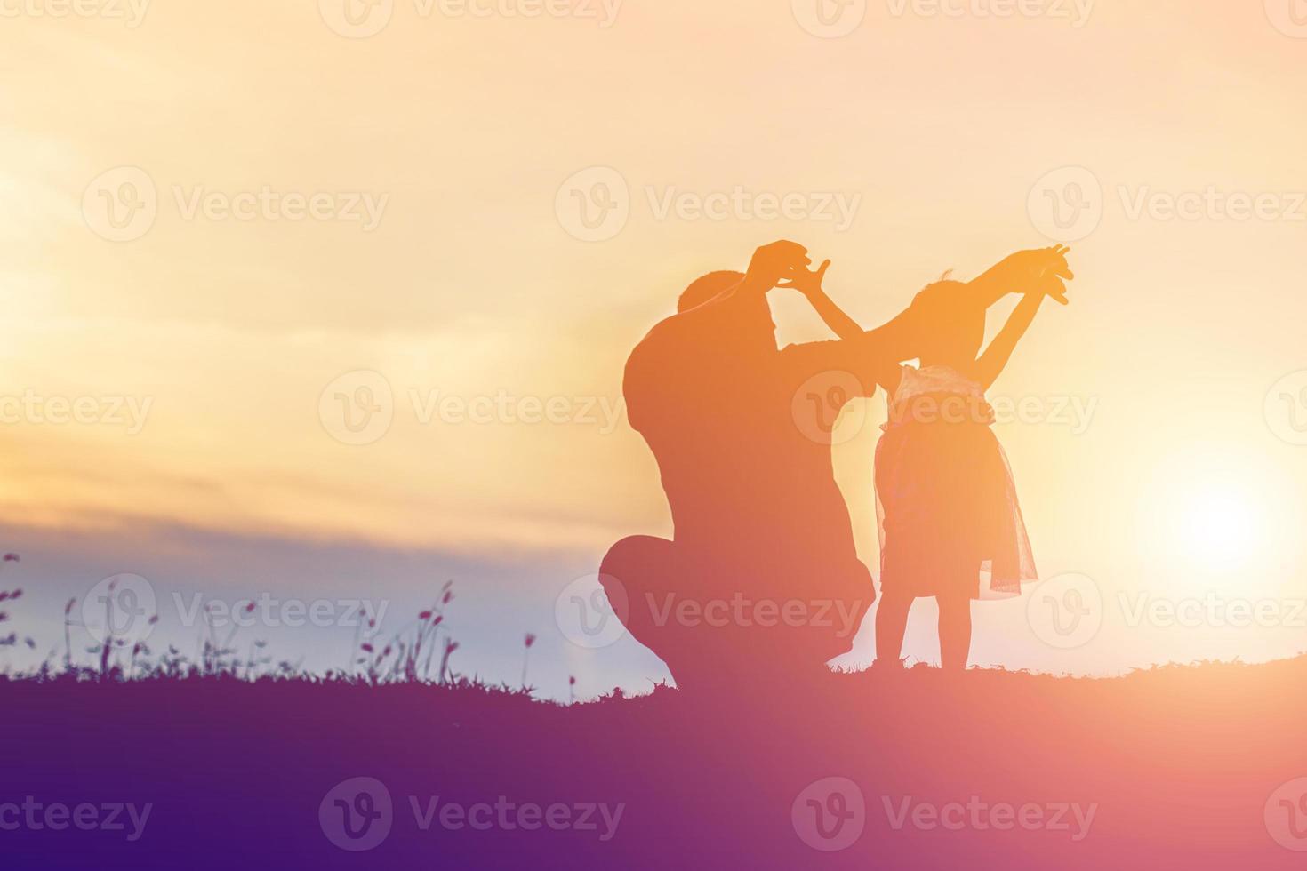 vader nam de baby leren lopen bij zonsondergang. foto