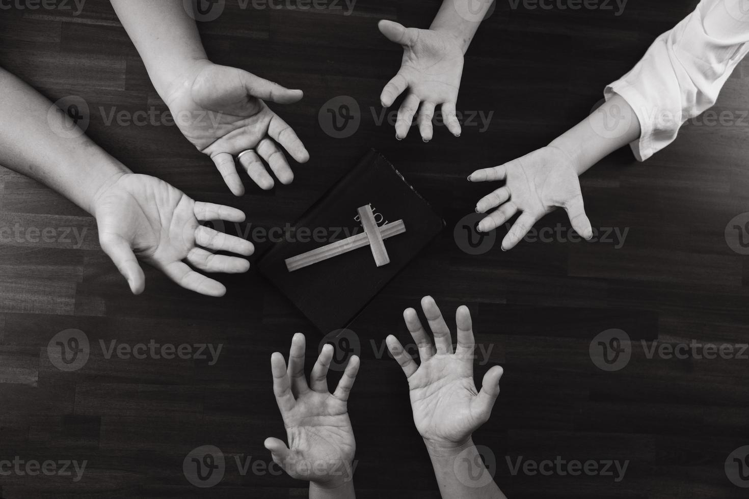 handen van jongeren bidden met kruisen op tafel, concept van hoop, geloof, christendom, kerk online. foto