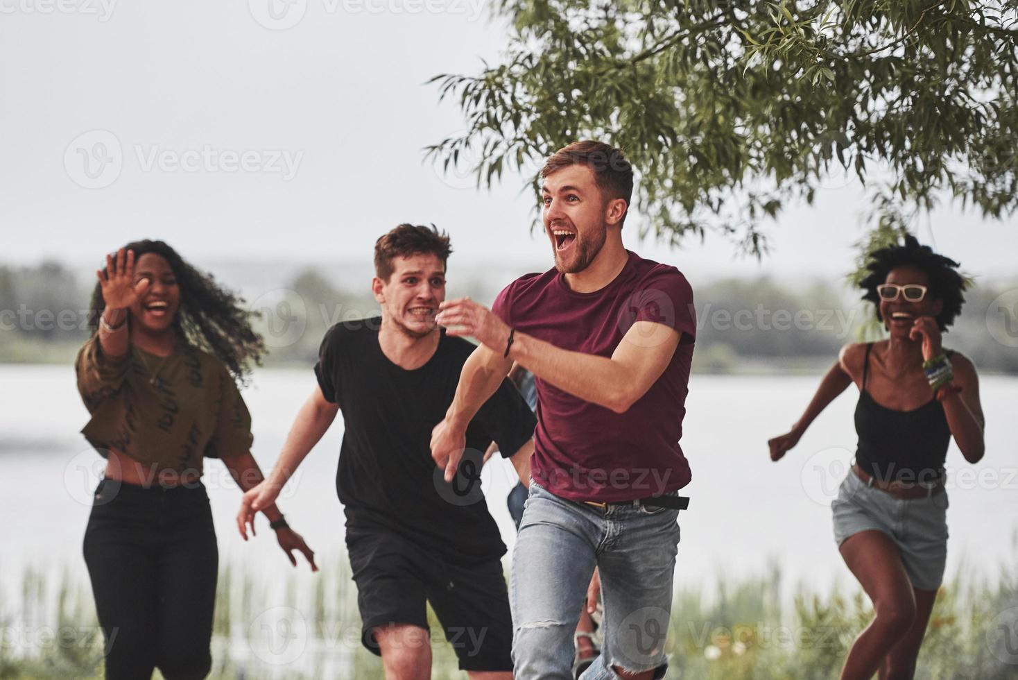 vang me als je kunt. mensen hebben feest buiten. multi-etnische vrienden ontmoeten elkaar in het weekend foto