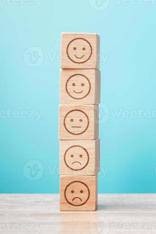 emotie gezicht blokken op blauwe achtergrond. servicebeoordeling, rangschikking, klantbeoordeling, tevredenheid, evaluatie en feedbackconcept foto