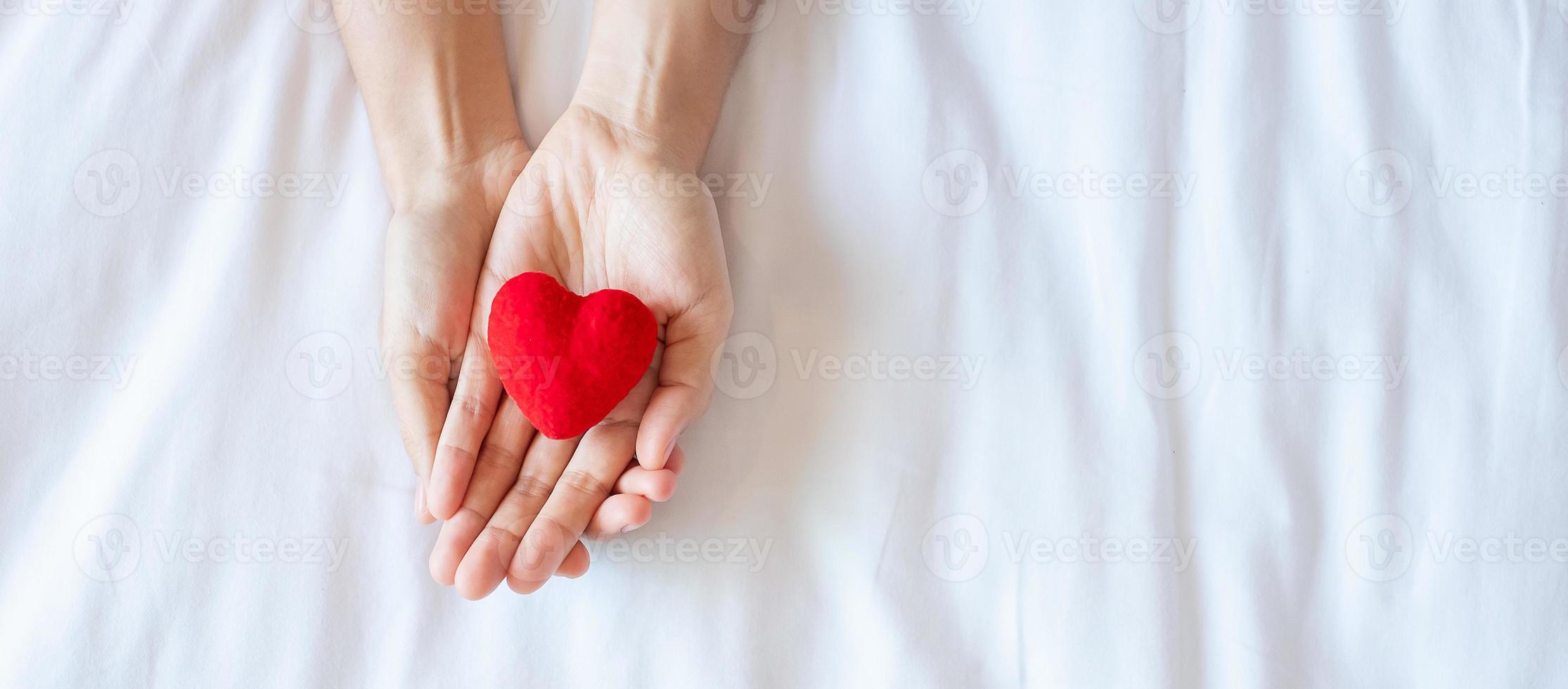 vrouw met rood hart vorm op witte achtergrond. gezondheidszorg, levensverzekeringen, donatie, gezondheid en wereldhartdagconcept foto