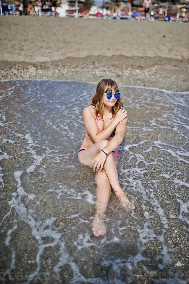 mooi model ontspannen op een strand gekleed in een zwembroek. foto