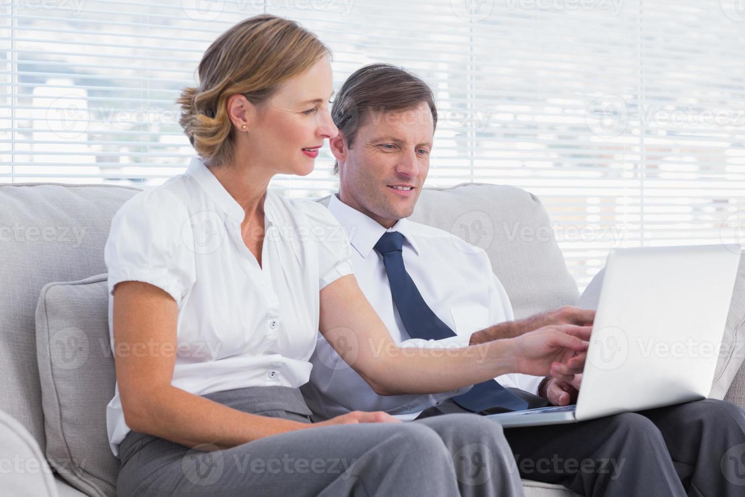 mensen uit het bedrijfsleven kijken iets op laptop foto