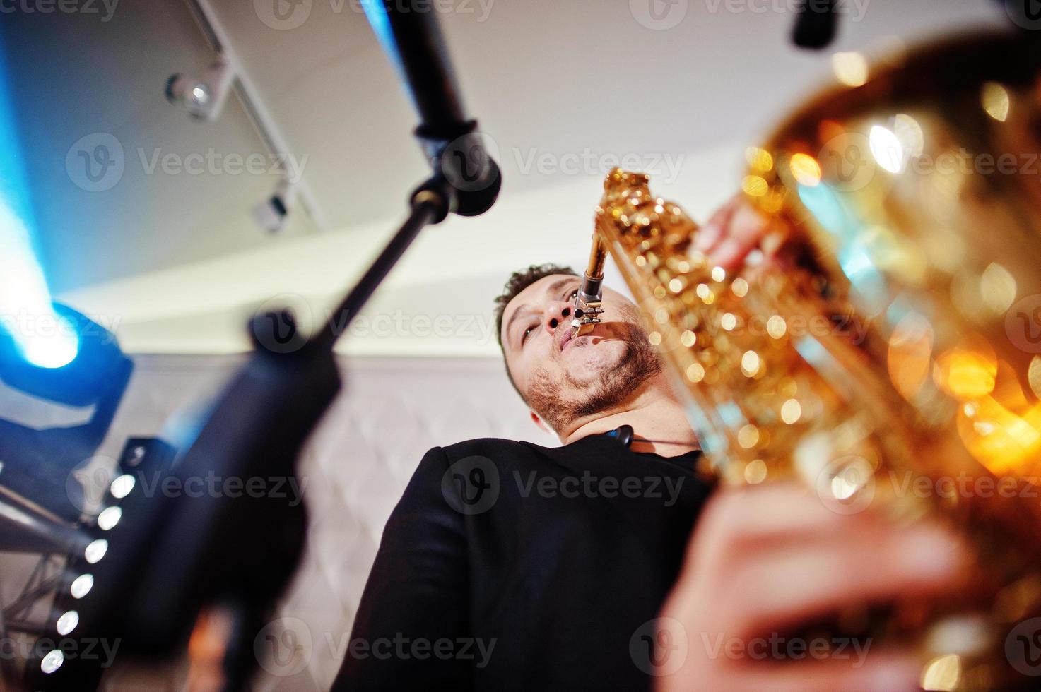 muzikale muziek live band die optreedt op een podium met verschillende lichten. saxofonist speelt. foto