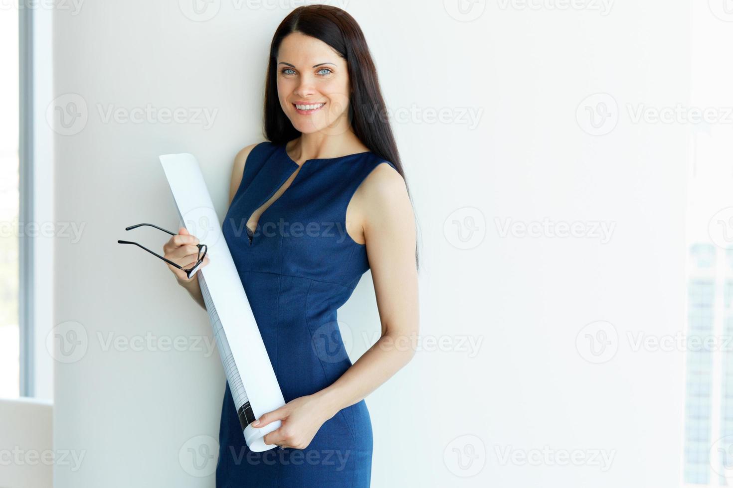 jonge vrouwelijke architect standind in een kantoor. mensen uit het bedrijfsleven foto