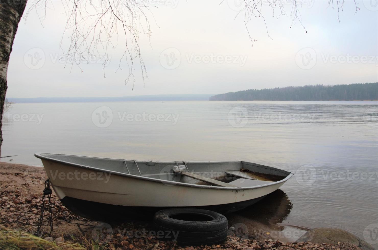 boot aan de oever van een rustig meer, landschap in neutrale kleuren foto