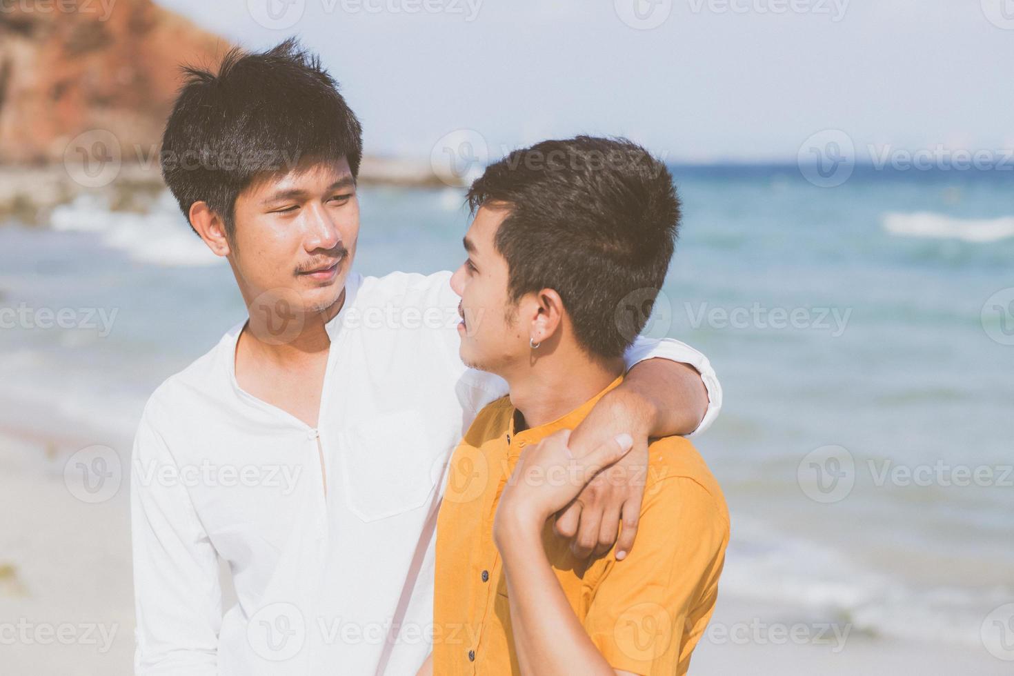 homoseksueel portret jong aziatisch paar staande knuffel samen op het strand in de zomer, azië homo gaand toerisme voor vrije tijd en ontspannen met romantisch en geluk in vakantie op zee, lgbt-concept. foto