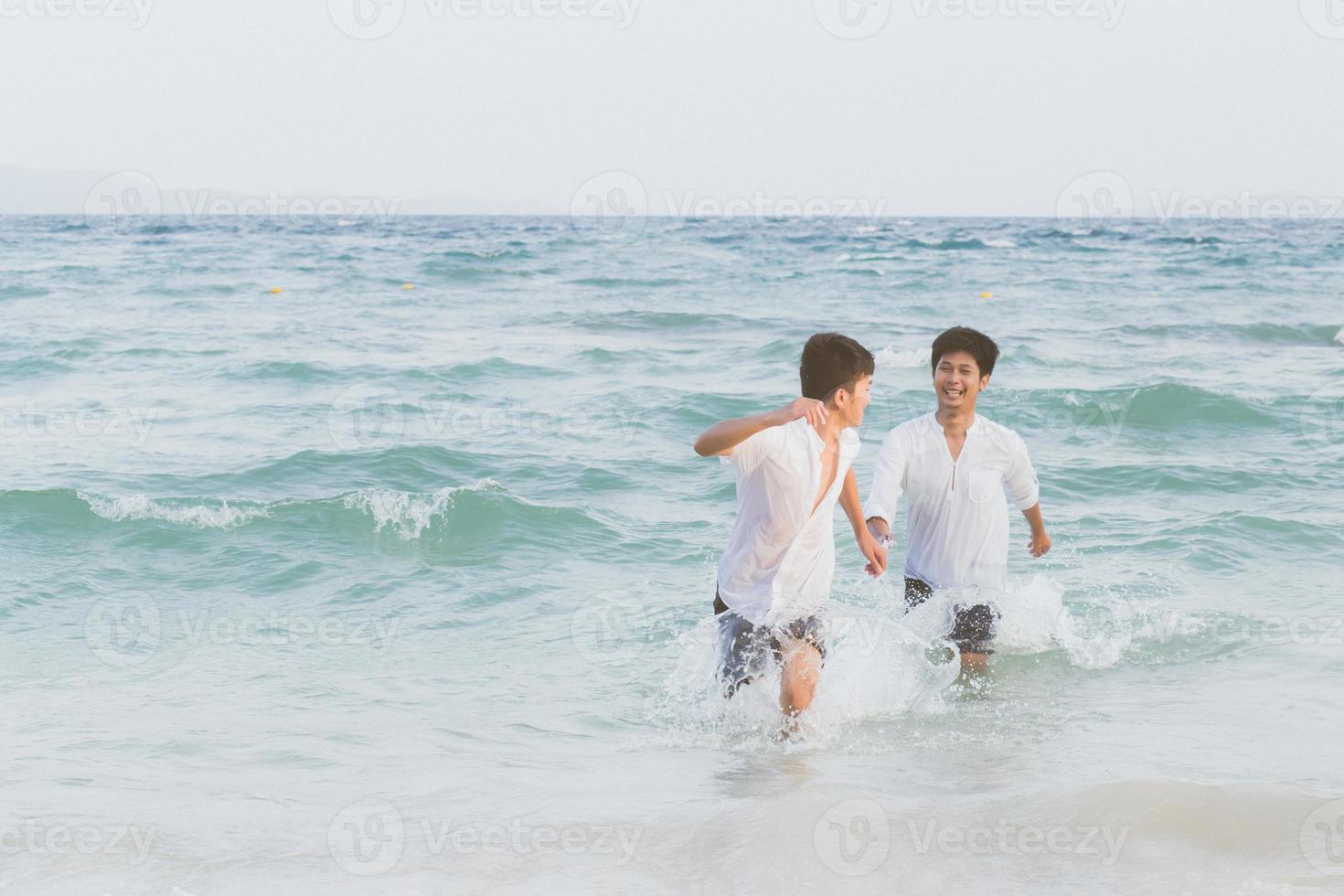 homoseksueel portret jonge aziatische paar lopen met vrolijk samen op het strand in de zomer, azië gay gaan toerisme voor vrije tijd en ontspannen met geluk in vakantie op zee, lgbt juridisch concept. foto