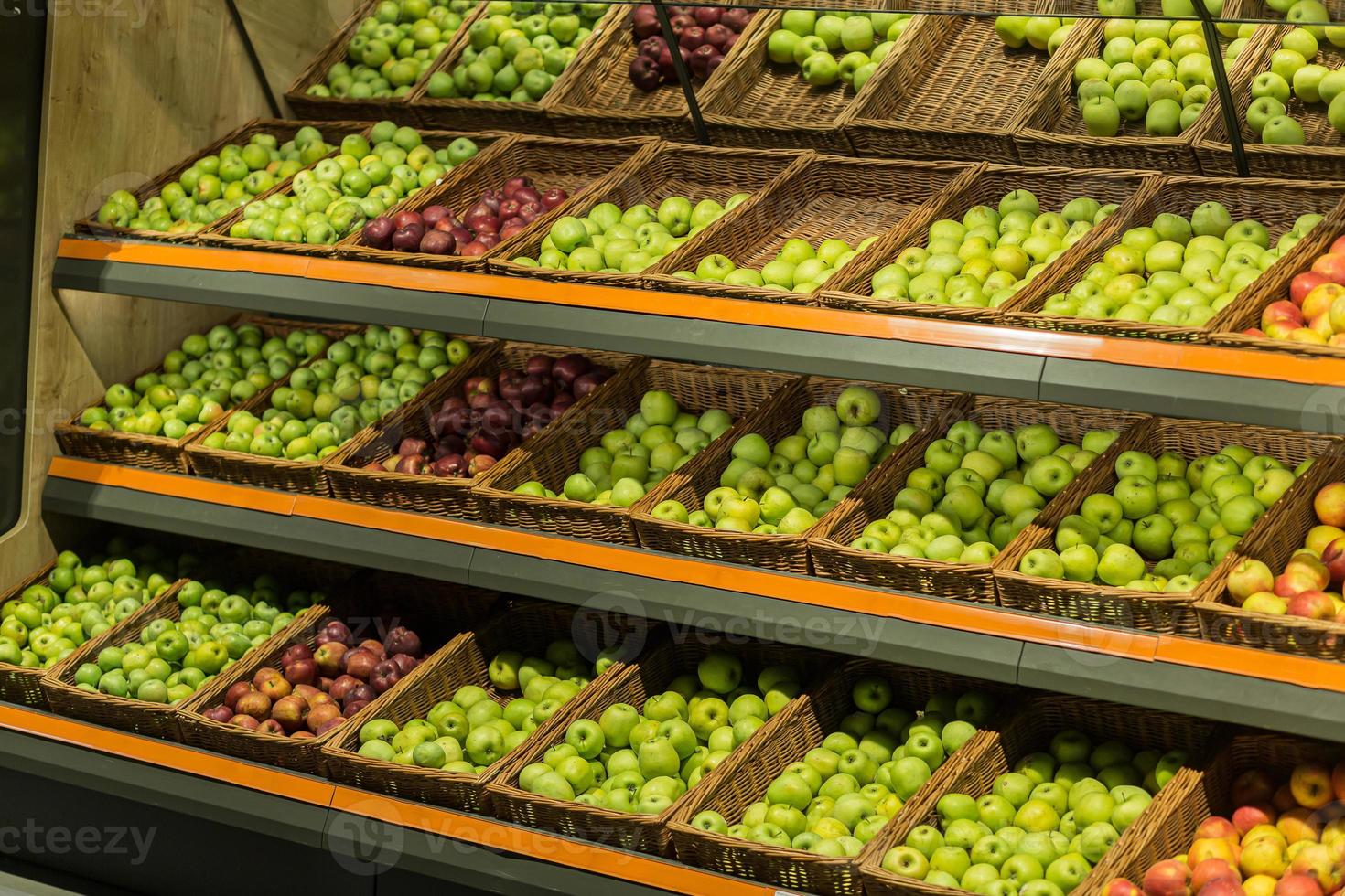 planken dozen met fruit kleurrijke appels in de supermarkt op het aanrecht foto
