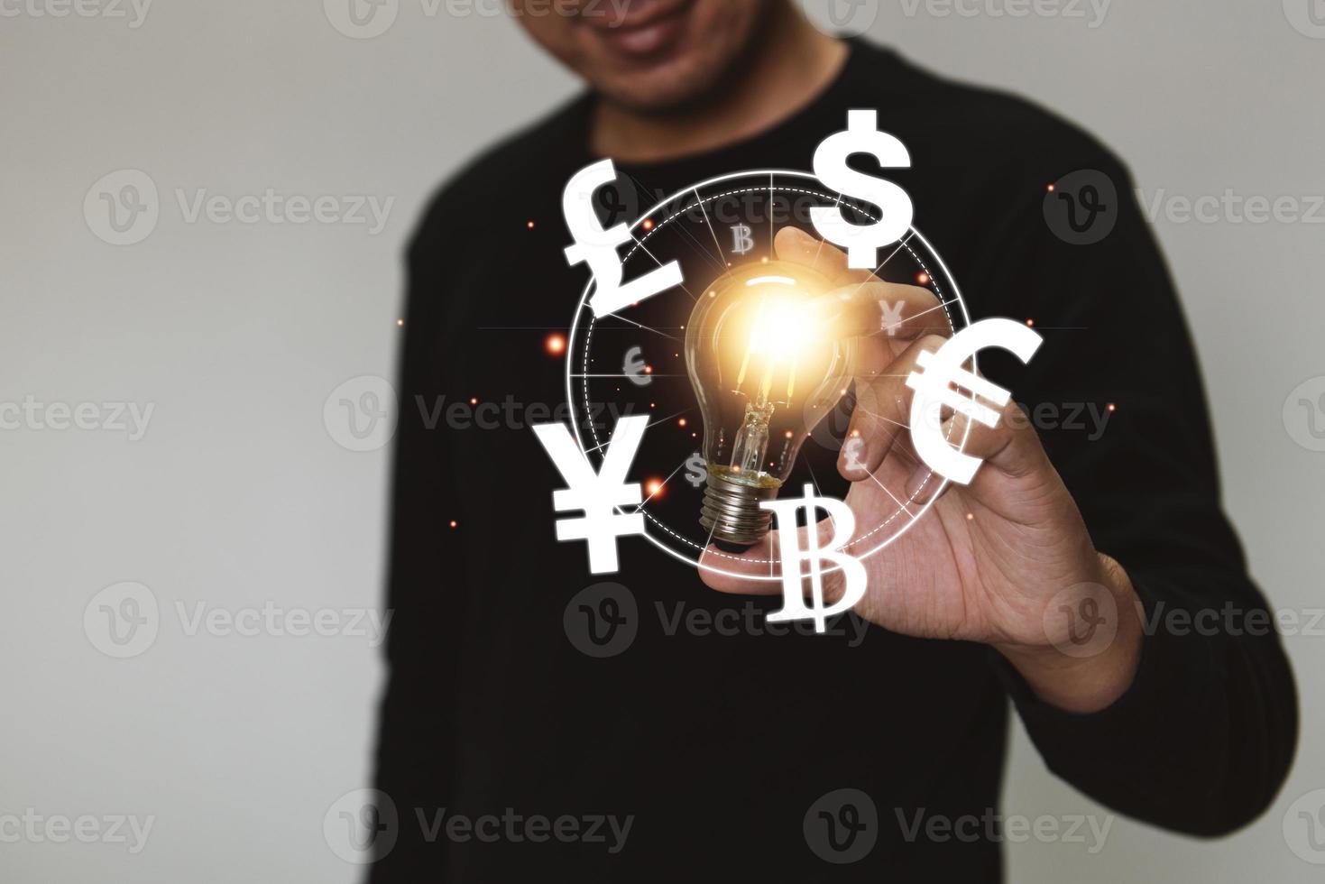 hand met een gloeilamp stijgt op met investeringen voor bedrijfsgroei en dollar yuan yen euro en pond sterling teken. wereldwijd valutawisselconcept foto