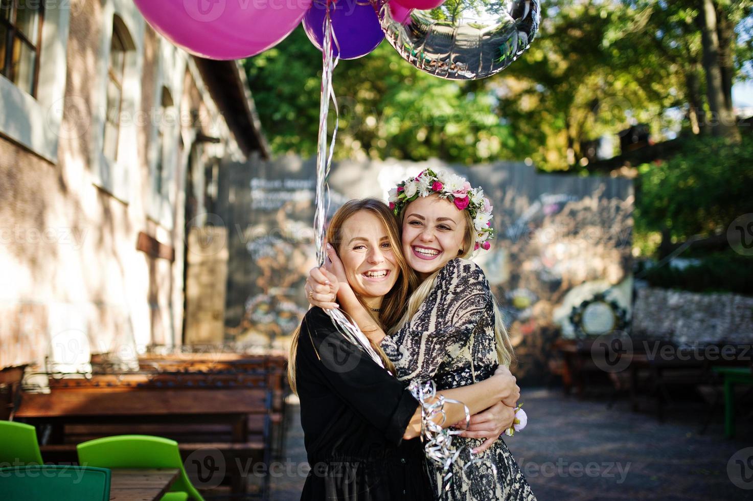 twee meisjes dragen op zwart met ballonnen op vrijgezellenfeest. foto