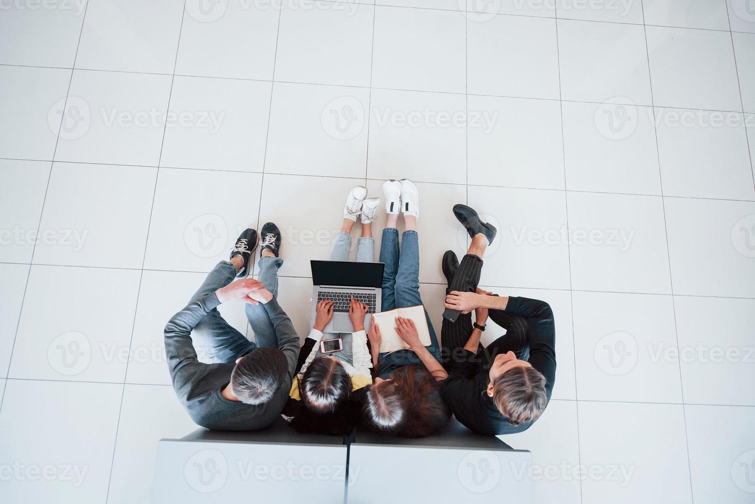 typen op toetsenbord. bovenaanzicht van jonge mensen in vrijetijdskleding die in het moderne kantoor werken foto