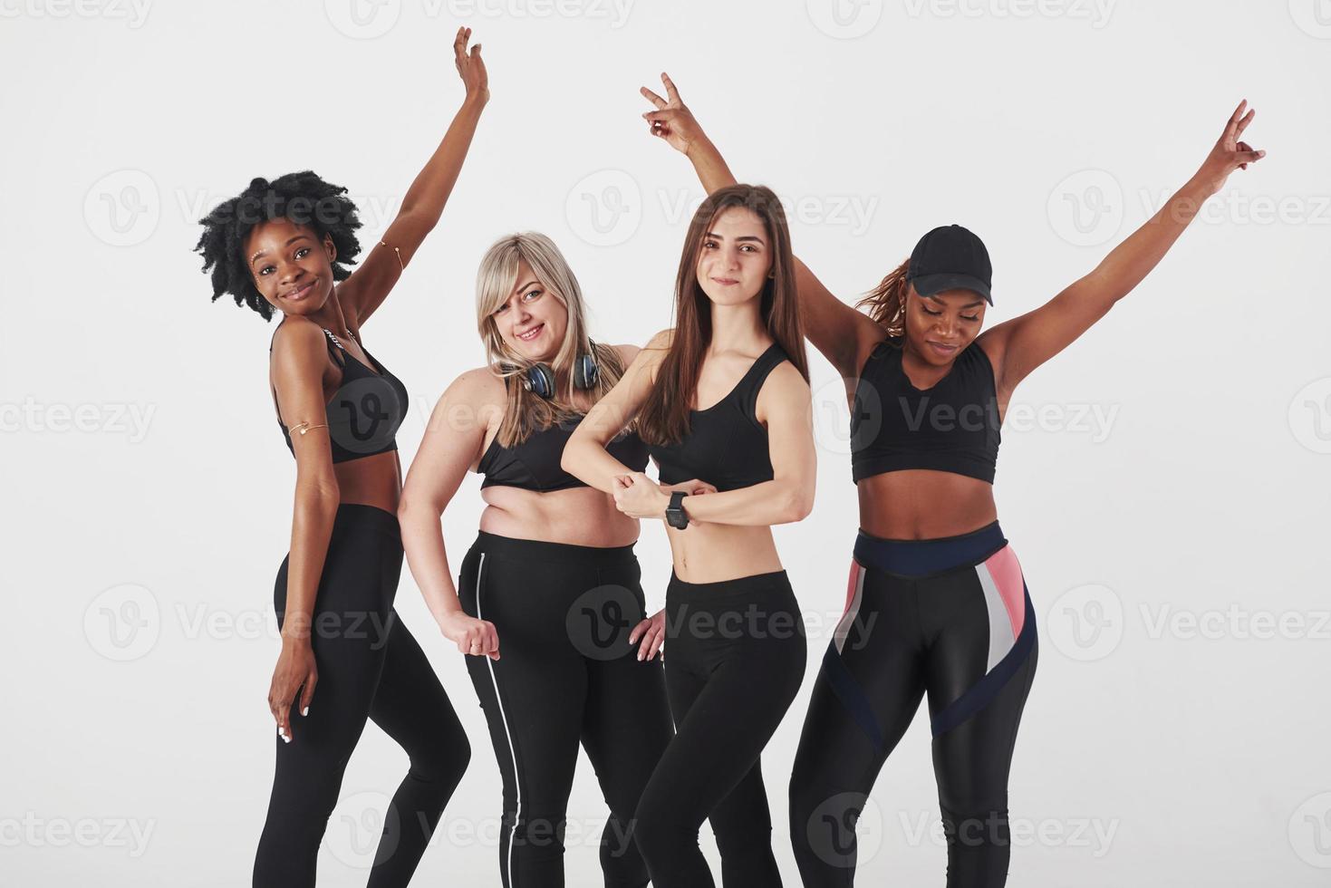 de lichamen laten zien. groep multi-etnische vrouwen die in de studio staan tegen een witte achtergrond foto