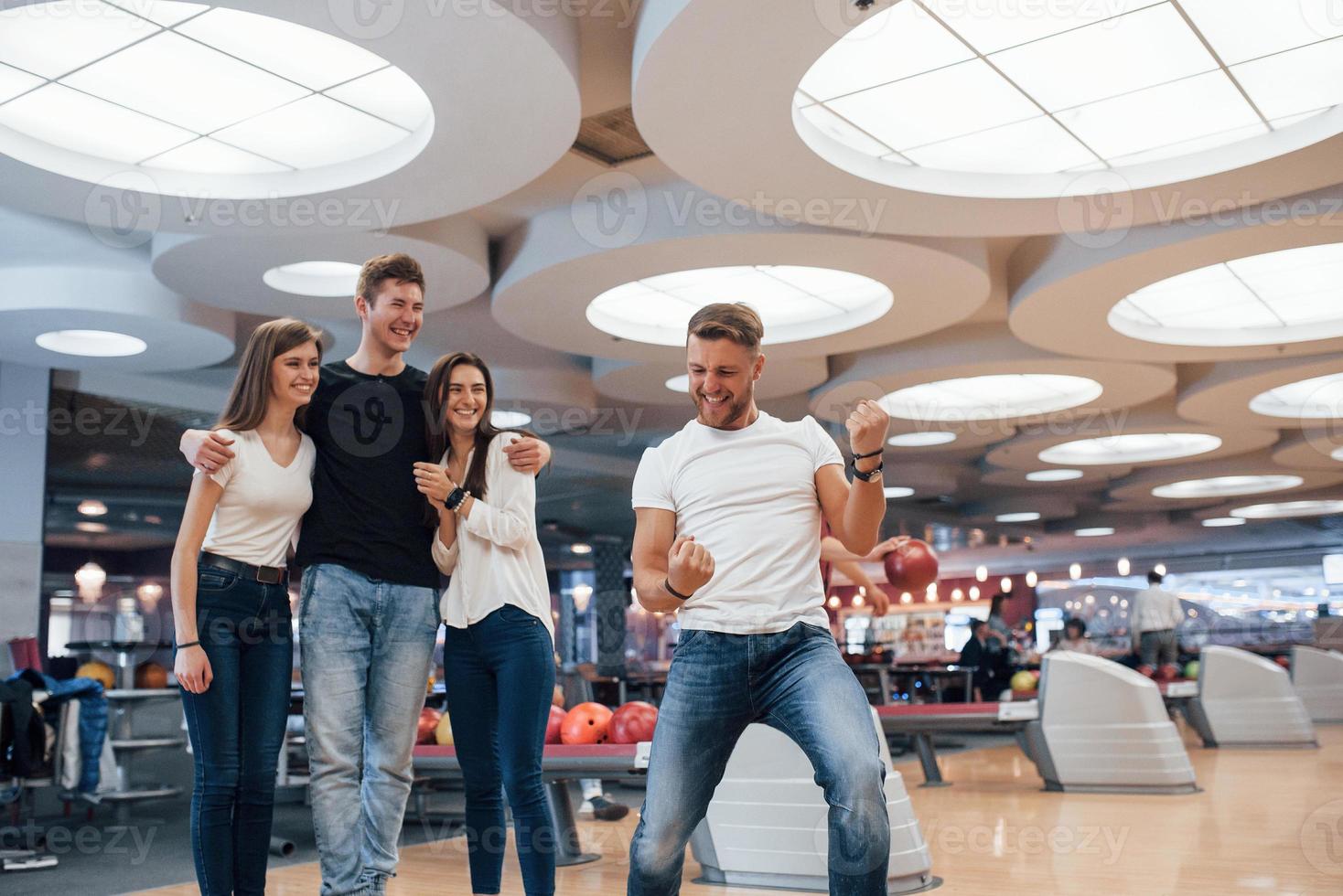 wie is de winnaar. jonge vrolijke vrienden hebben plezier in de bowlingclub in hun weekenden foto