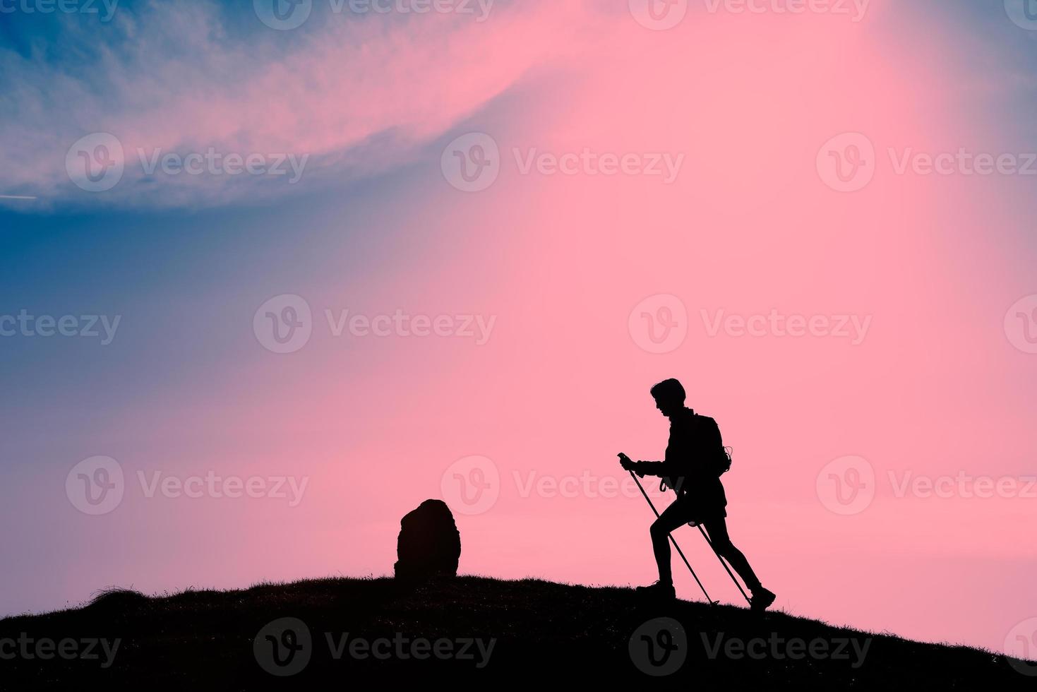 silhouet van meisje dat trekking maakt in een roze zonsondergang foto