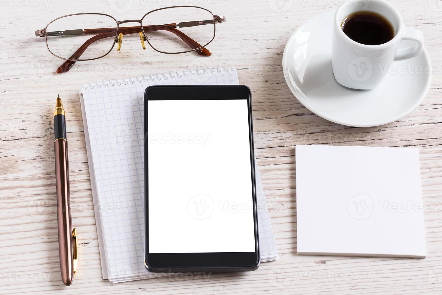 notebook met bril, potlood, smartphone en koffiekopje foto
