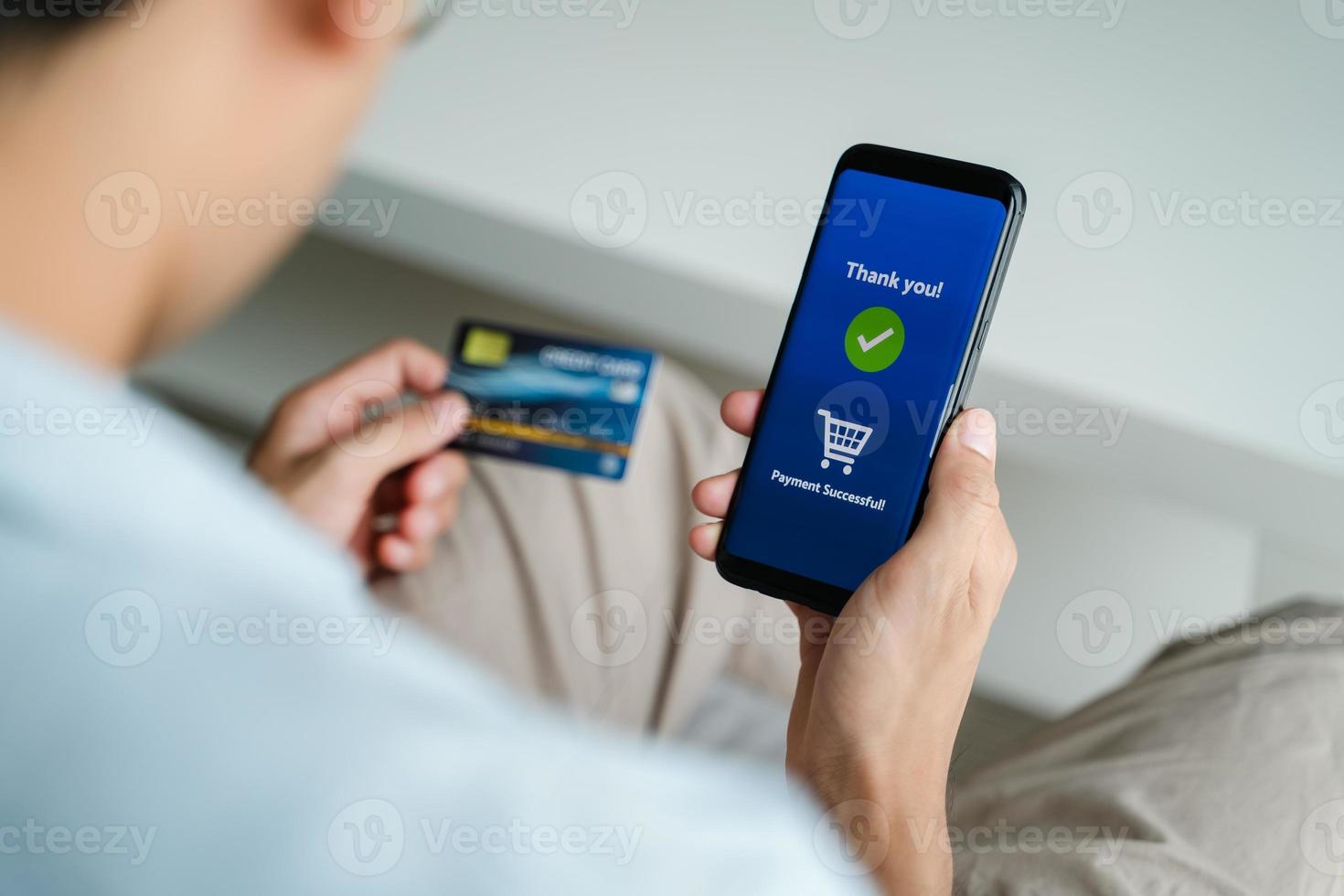 man met creditcard en smartphone gebruiken voor online winkelen, internetbankieren, e-commerce, geld uitgeven, thuiswerken concept foto