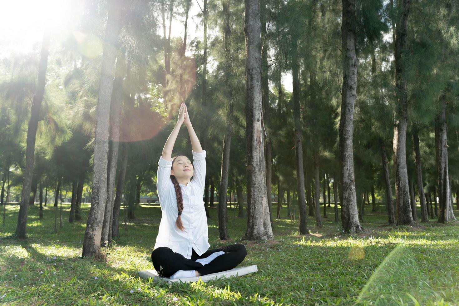 meisje doet yoga pose in het park in de ochtend met zonlicht. foto
