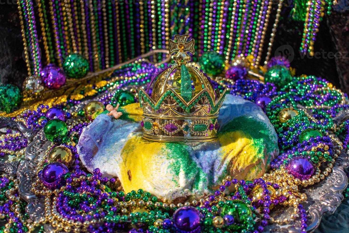 mardi gras koningstaart gegarneerd met kroon omringd door kralen en decoraties foto
