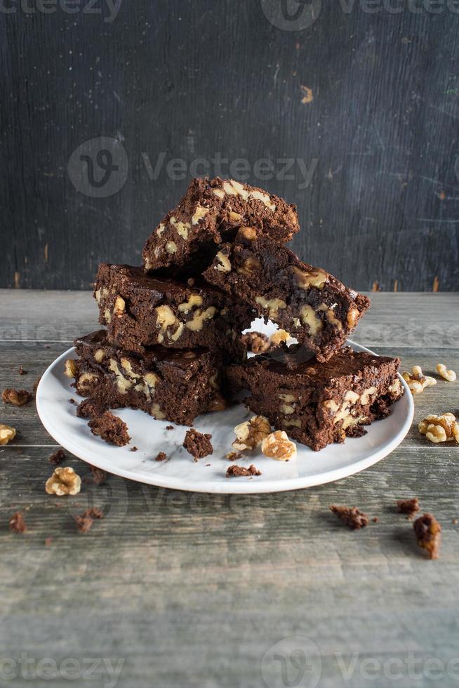 stapel zelfgemaakte walnoot en chocolade brownies op plaat foto