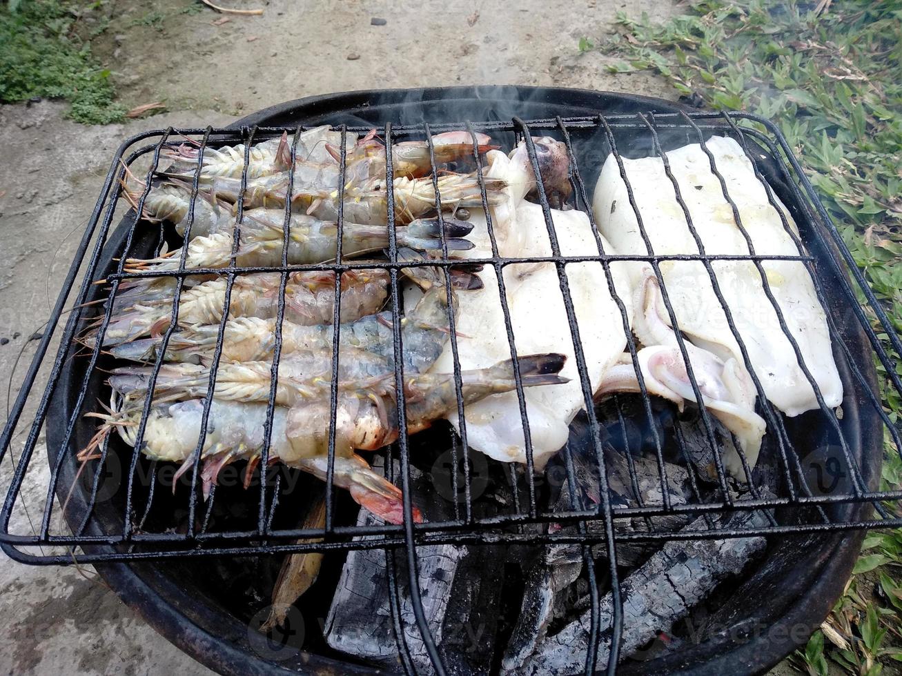 gegrilde inktvis en garnalen op de grill. Indonesisch culinair eten foto