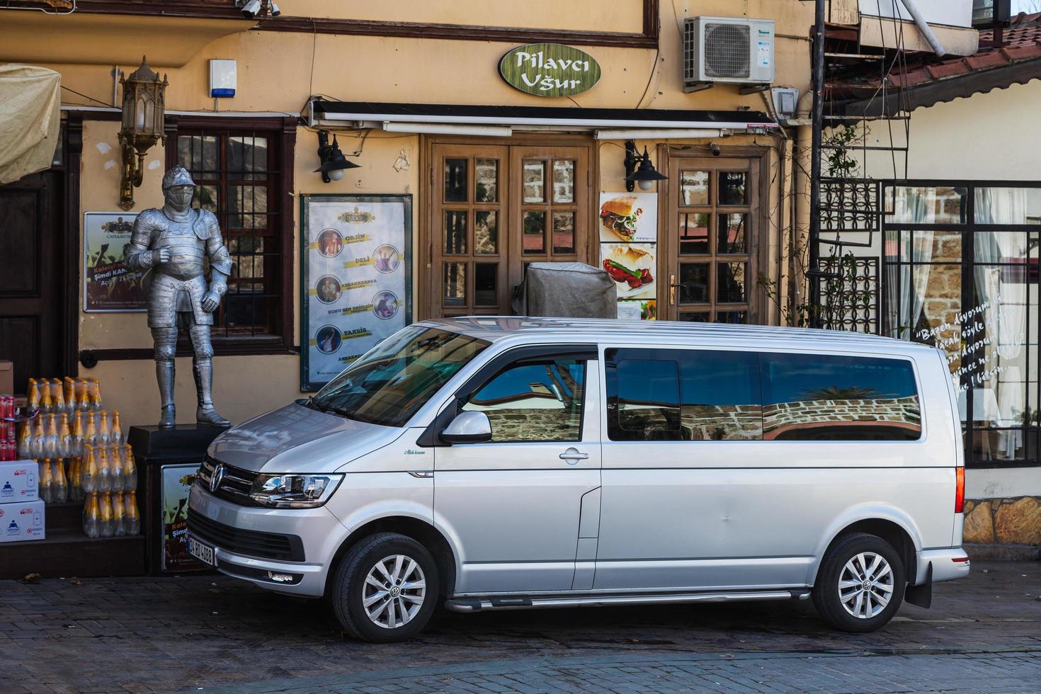 Side Turkije 20 februari 2022 Zilveren Volkswagen Transporter staat geparkeerd op straat op een warme zomerdag tegen de achtergrond van een winkel foto