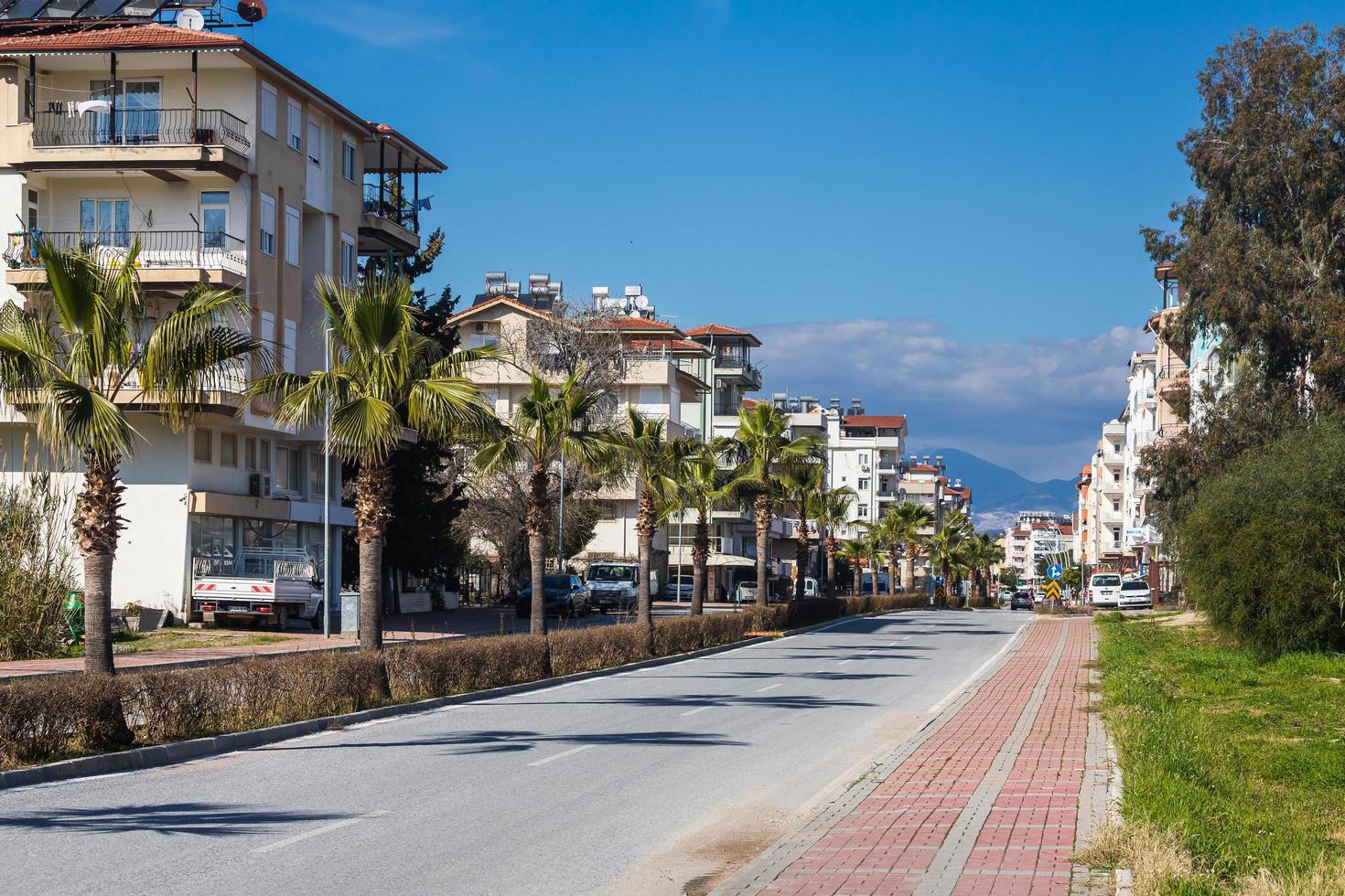 kant turkije 01 maart 2022 stadsstraat met huizen met meerdere verdiepingen van hetzelfde type, geparkeerde verschillende auto's, winkels, bergen foto