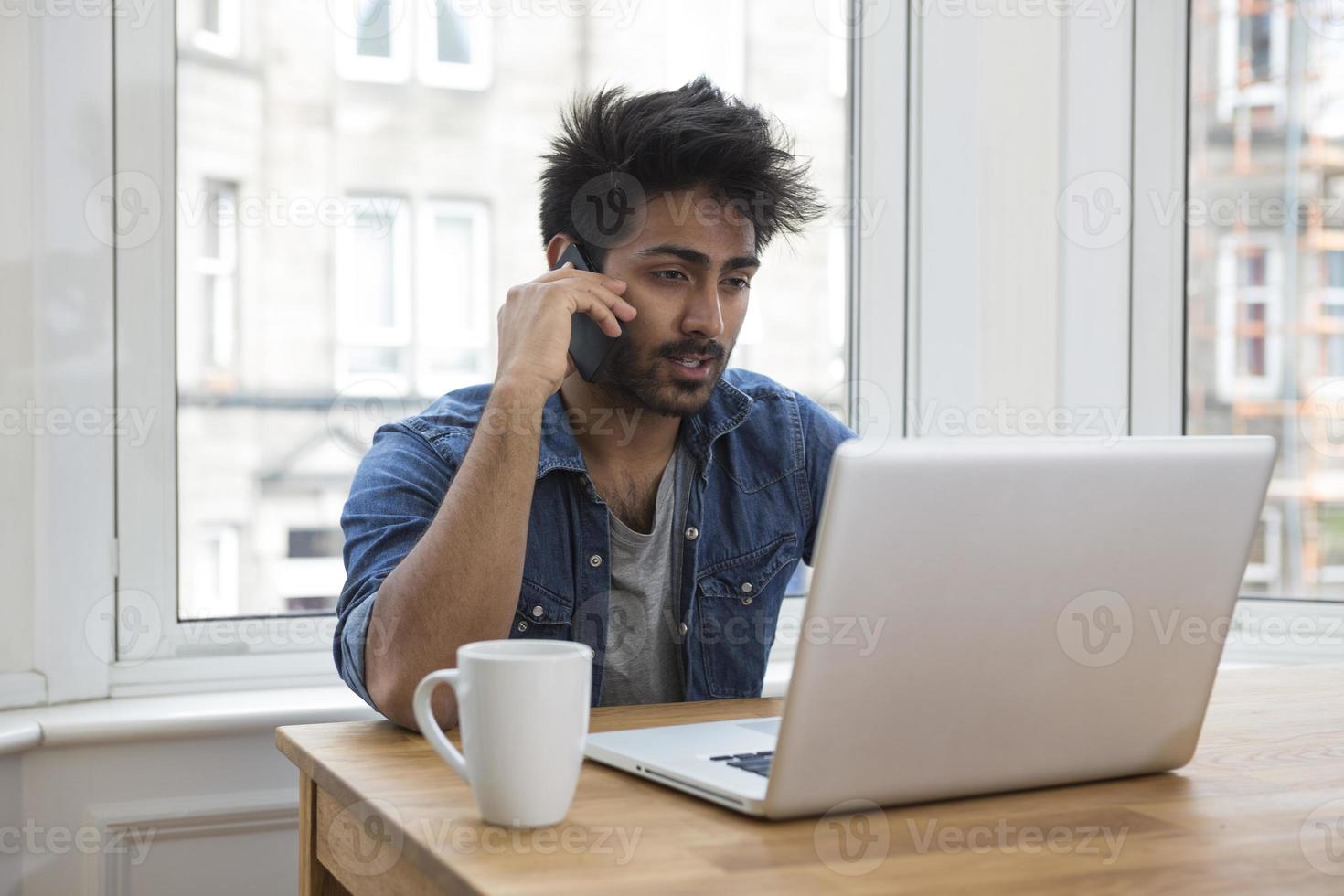 Aziatische man thuis werken op laptop. foto