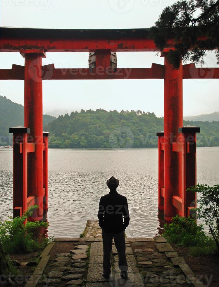 man die in de buurt van torii in hakone, japan staat foto