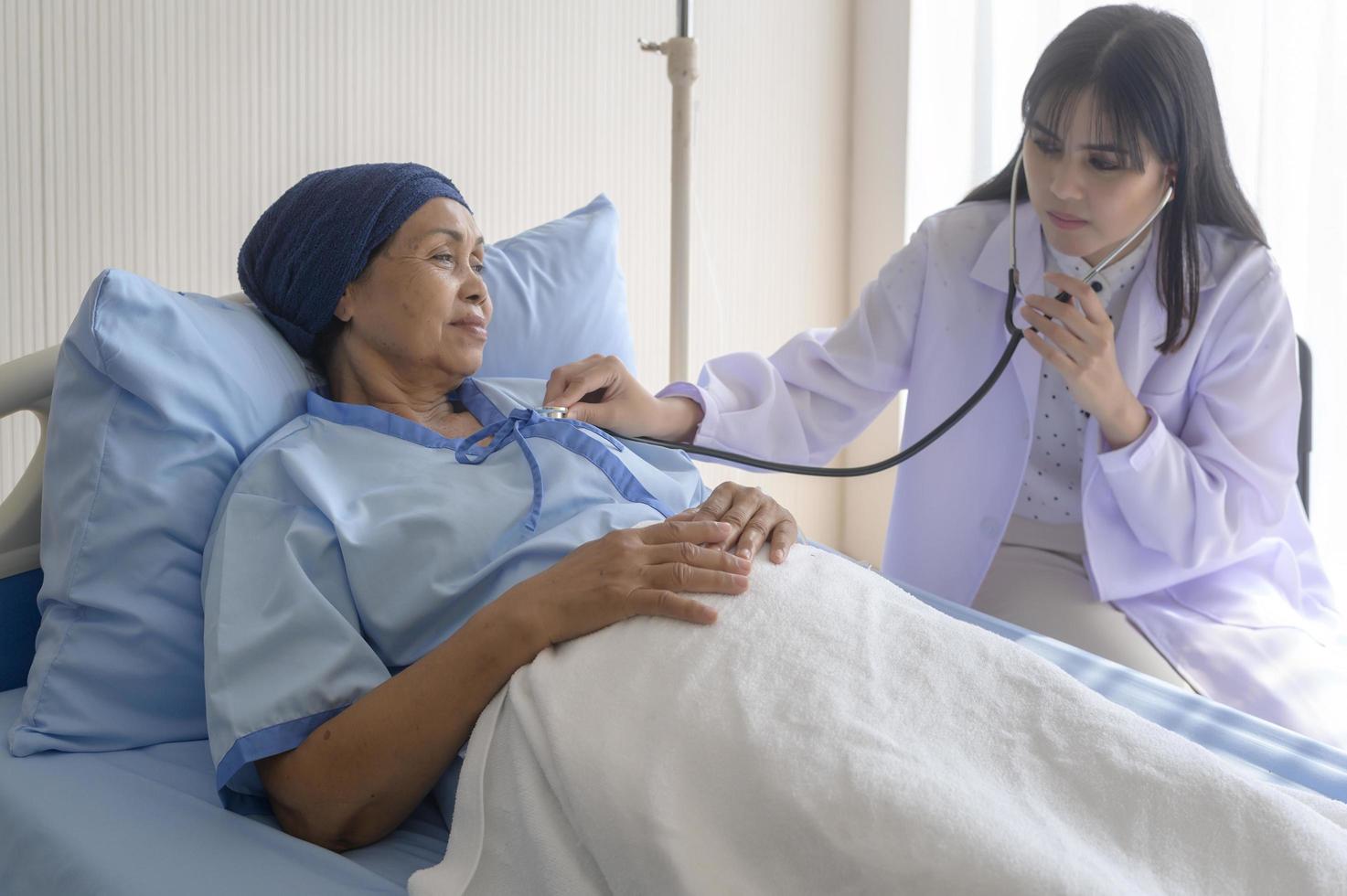 kankerpatiënt vrouw met hoofddoek na chemotherapie consultatie en bezoekende arts in het ziekenhuis.. foto