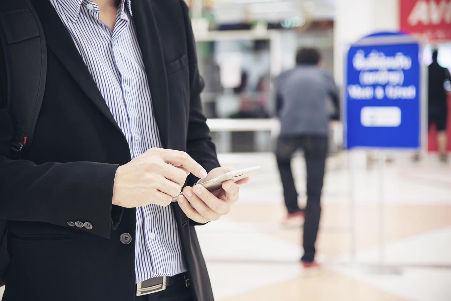 zakenman die mobiele telefoon gebruikt tijdens zijn buitenwerk - moderne zakenman met mobiele technologiecommunicatie foto