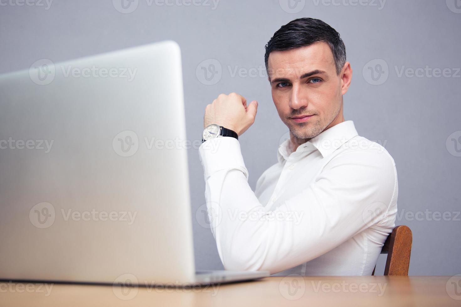 zakenman zitten aan de tafel met laptop foto