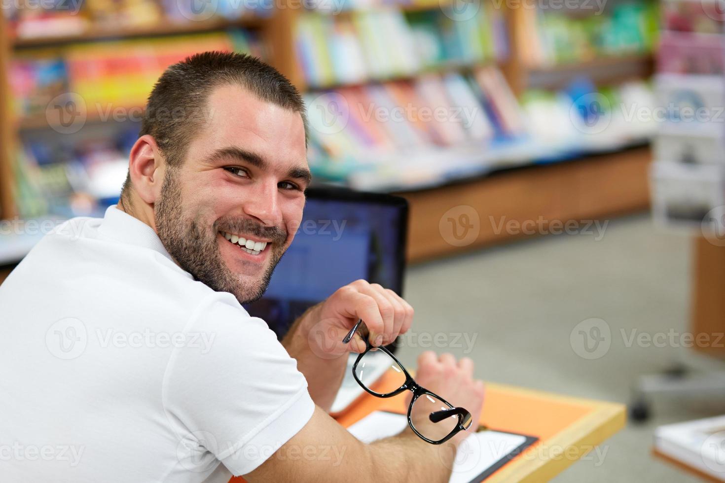 portret van een man met bril in boekhandel foto
