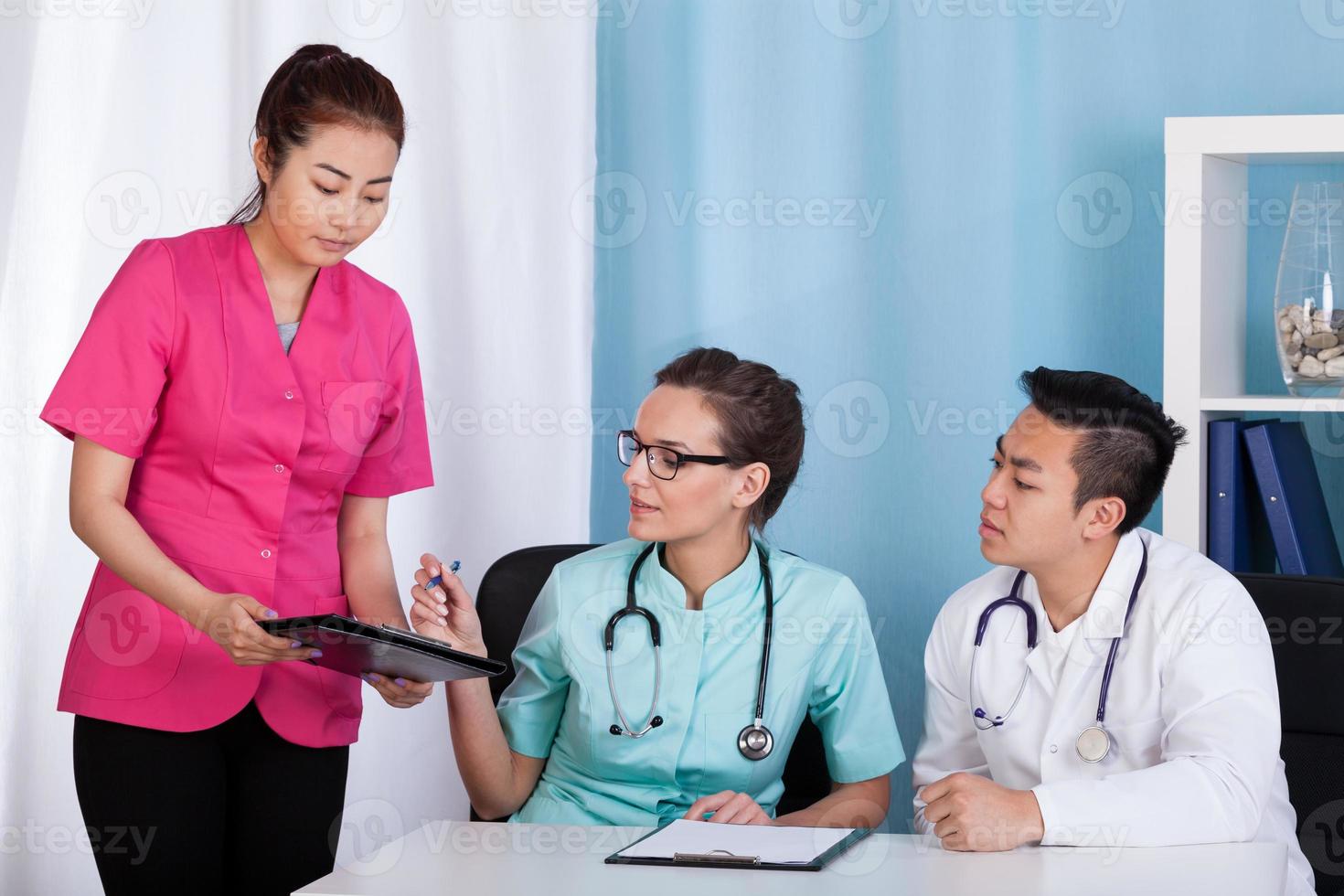Aziatische en blanke artsen tijdens werk foto