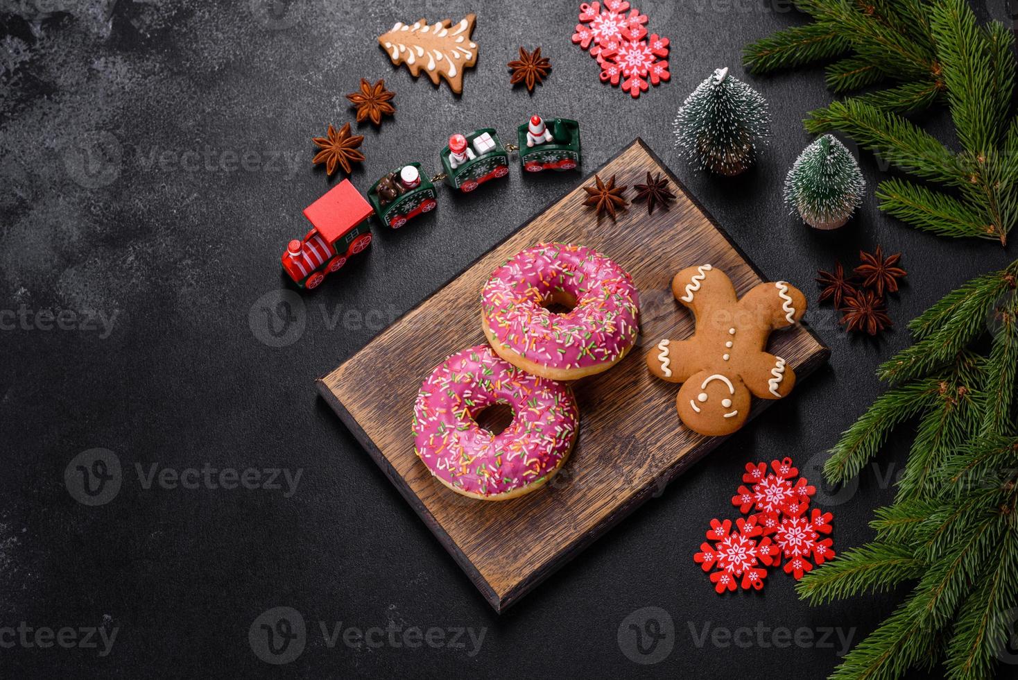 een mooie donut met roze glazuur en gekleurd strooisel op een kersttafel foto