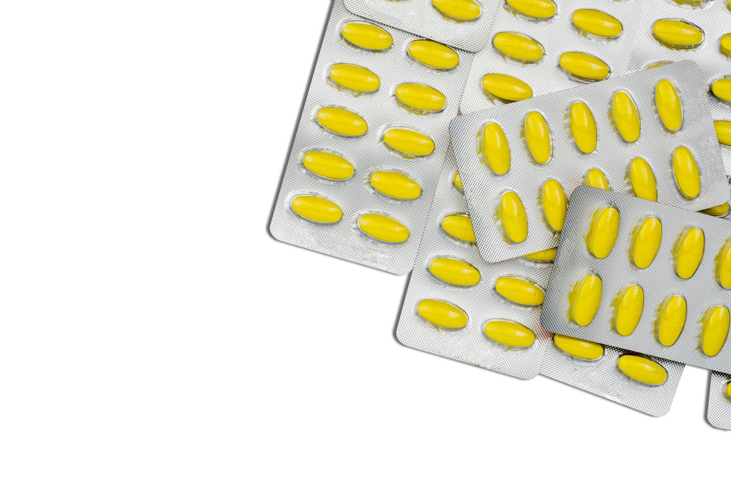 bovenaanzicht van ovale gele tabletten pillen in blisterverpakkingen. gele pillen patroon behang. mefenaminezuur tabletten pillen voor verlichting van pijn, menstruatiekrampen, hoofdpijn en kiespijn. foto