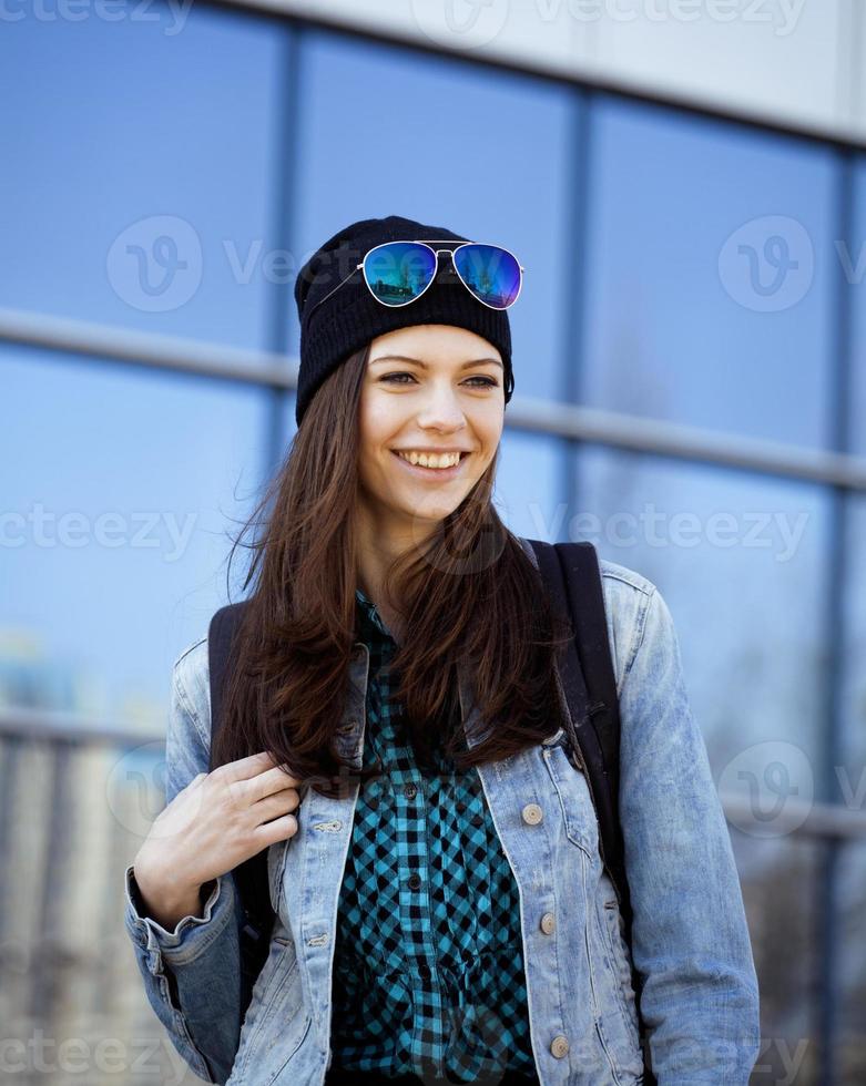 schattige brunette tiener meisje in hoed, student buiten foto