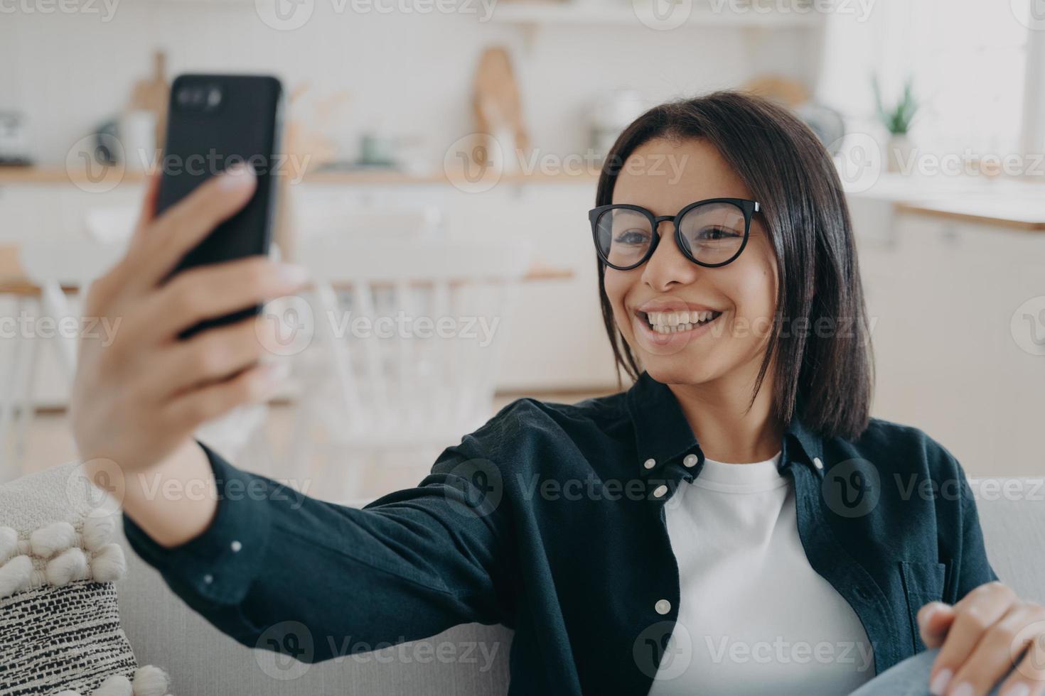 video telefoongesprek. gelukkig gemengd ras vrouw is ontspannen en chatten op smartphone. foto