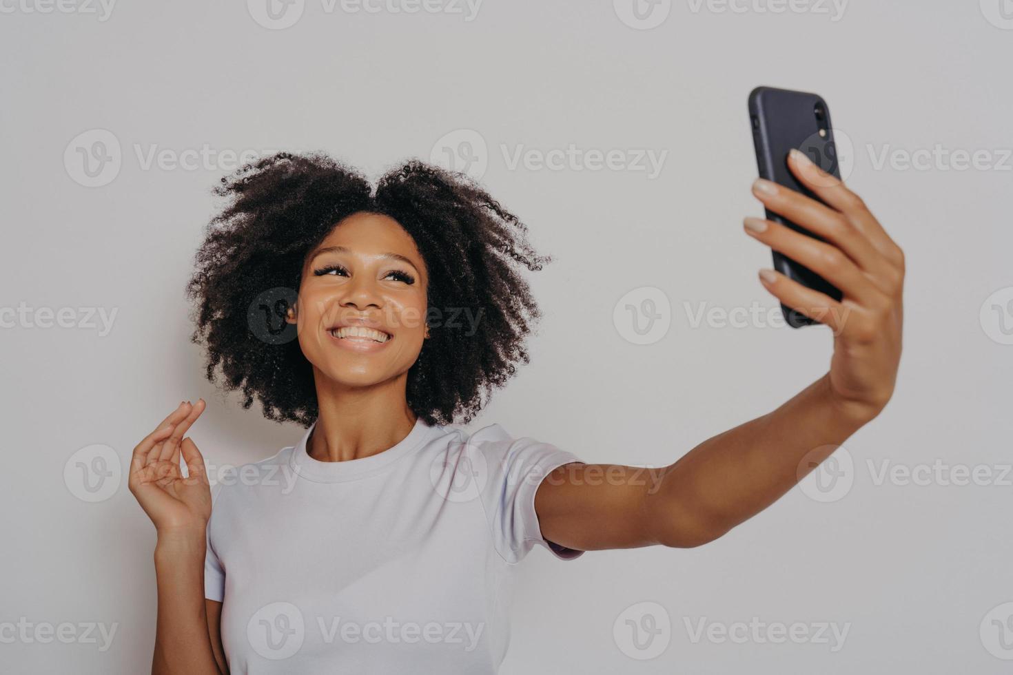 positieve vrolijke donkere vrouw die foto maakt op moderne smartphonecamera