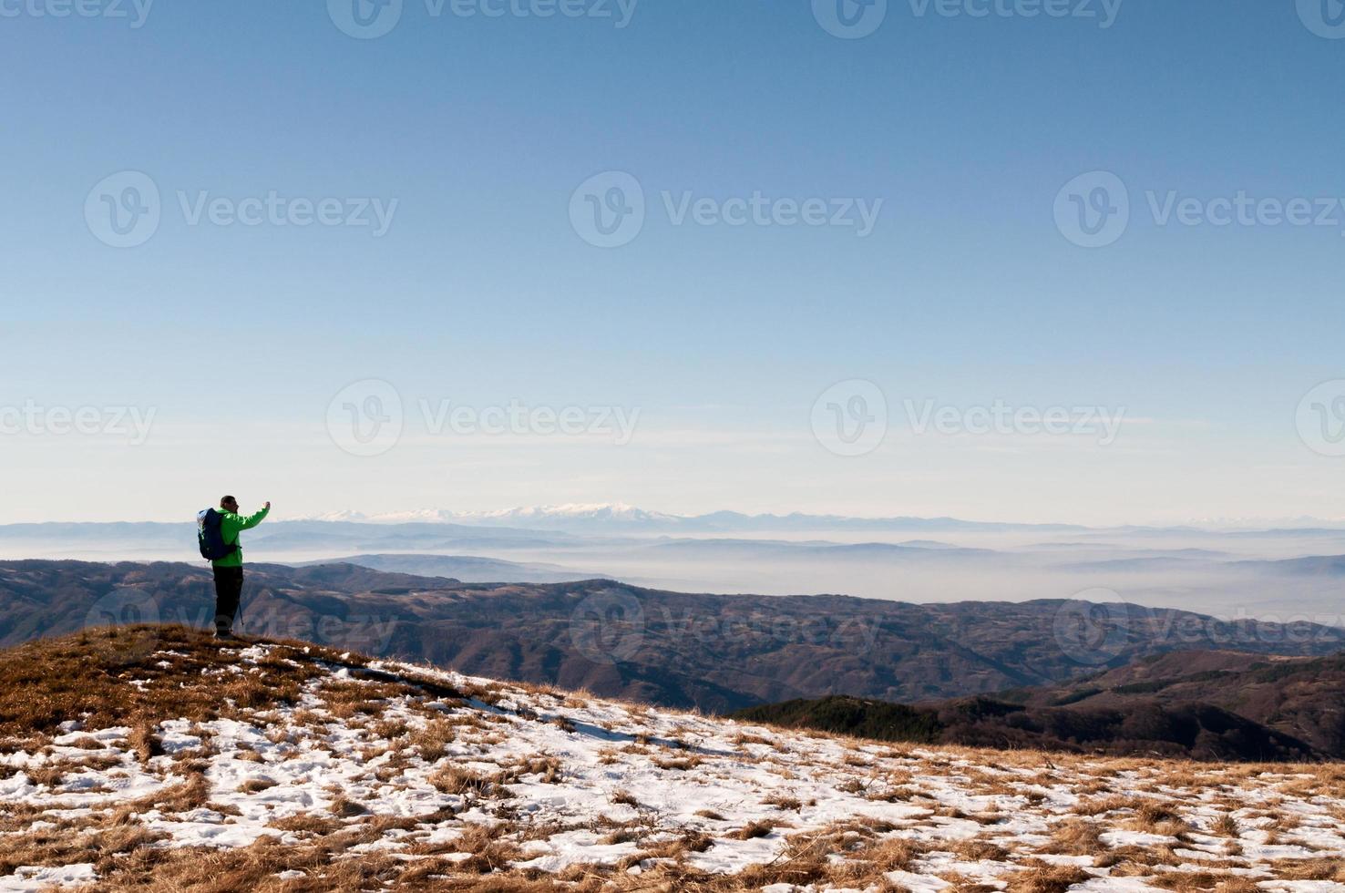wandelaar die foto met digitale camera op berg neemt