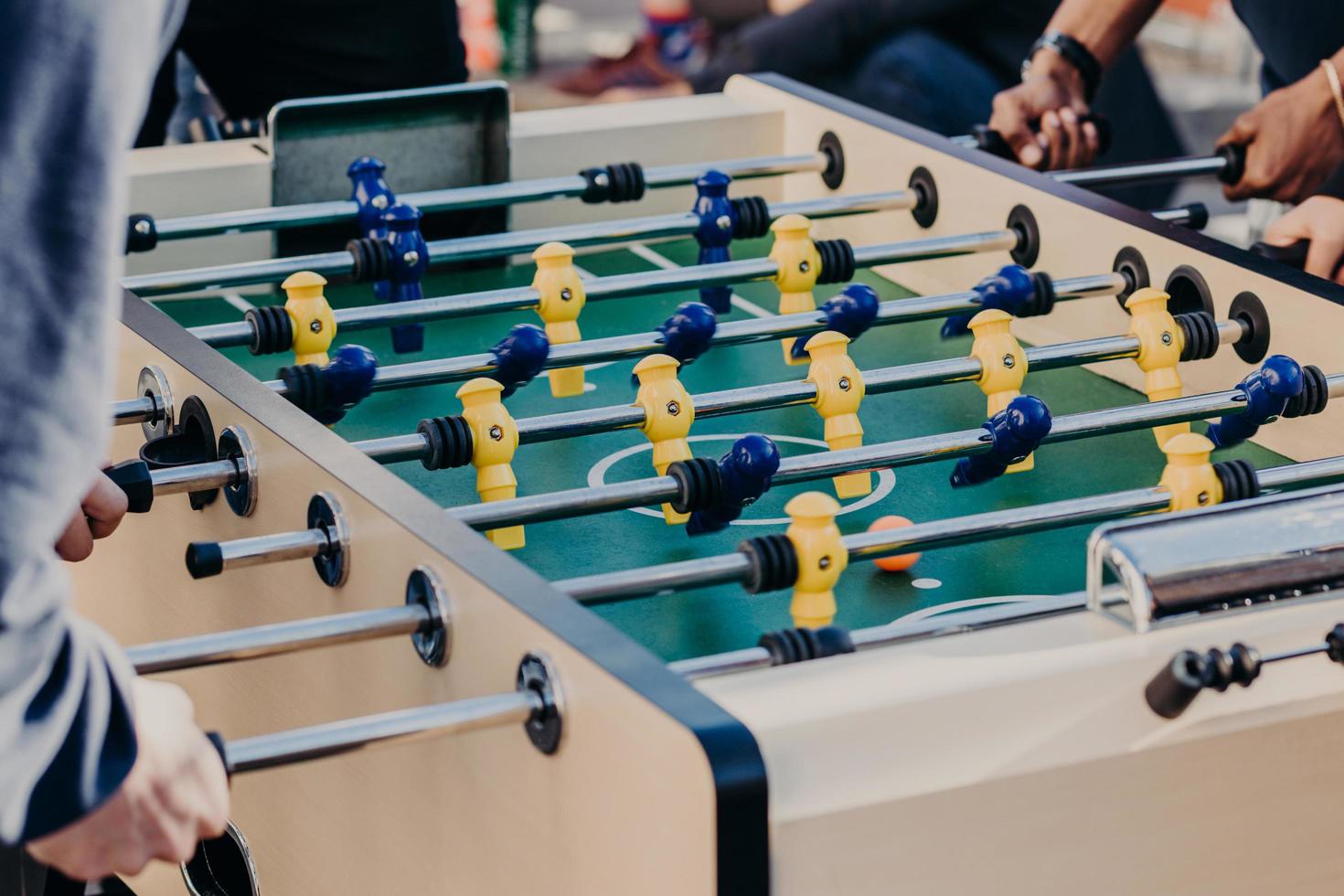 vrienden spelen tafelvoetbalspel, brengen vrije tijd door in het uitgaanscentrum. recreatie en vrije tijd concept. actieve spelers. sport spelletjes foto