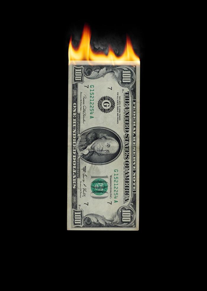 afbeelding van brandende dollar op zwarte achtergrond foto